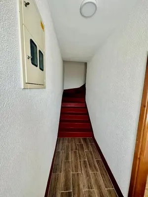 a stairway with a red floor and white walls at Guest House Djakonovic in Ulcinj