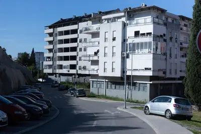 a white car parked in a parking lot next to a building at Anika apartment in Podgorica