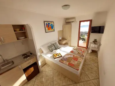 a small room with a bed and a kitchen at Apartmani Dalex in Budva