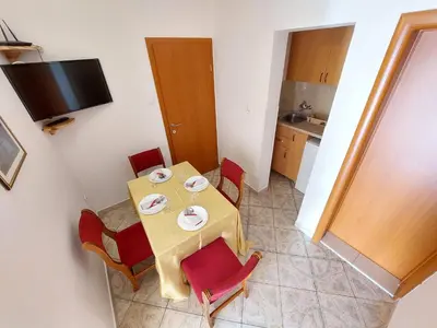 a table and chairs in a room with a kitchen at Apartmani Dalex in Budva