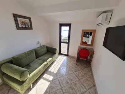 a living room with a green couch and a flat screen tv at Apartmani Dalex in Budva