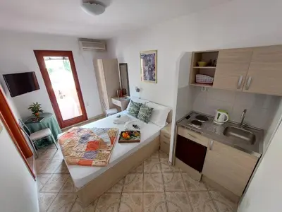 a small kitchen with a table with a plate of food on it at Apartmani Dalex in Budva
