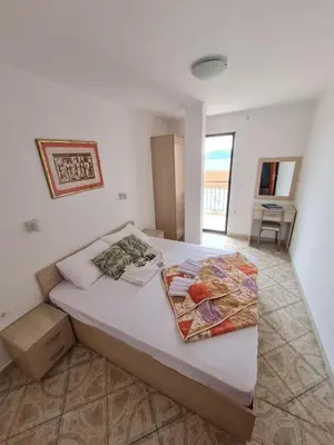 a bedroom with a large bed with white sheets at Apartmani Dalex in Budva