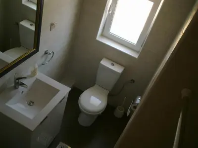 a bathroom with a toilet and a sink and a window at Mediteraneo Apartments in Budva