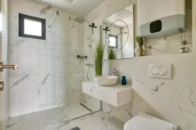 a white bathroom with a sink and a shower at Magic view - Apartment with Pool in Budva