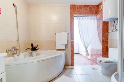a bathroom with a white tub and a toilet at Villa Jadranka Sutomore in Sutomore