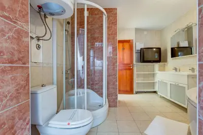 a bathroom with a shower and a toilet and a sink at Villa Jadranka Sutomore in Sutomore