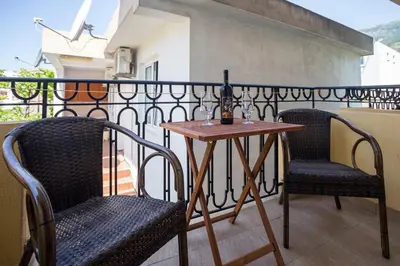a balcony with two chairs and a table on a balcony at Villa Jadranka Sutomore in Sutomore