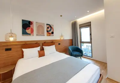 a bedroom with a bed and a blue chair at Stylish Apartment with Elegant Touches in Podgorica