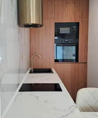 a kitchen with a sink and a microwave at Stylish Apartment with Elegant Touches in Podgorica