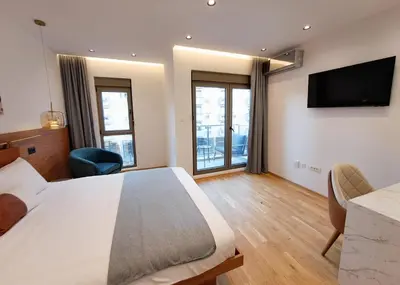 a hotel room with a bed and a flat screen tv at Stylish Apartment with Elegant Touches in Podgorica