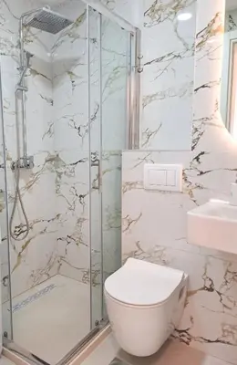 a bathroom with a toilet and a shower at Stylish Apartment with Elegant Touches in Podgorica