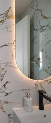 a bathroom with a mirror and a white sink at Stylish Apartment with Elegant Touches in Podgorica
