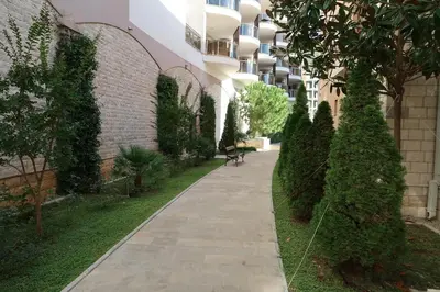 a walkway in front of a building with trees at Apartmani LUX Becici in Becici