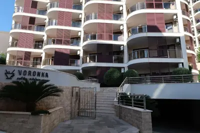 an apartment building with stairs in front of it at Apartmani LUX Becici in Becici