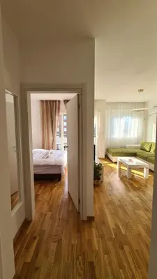 a bedroom with a bed and a living room at Zoya Apartment in Podgorica