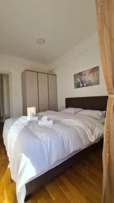 a bedroom with a large white bed with towels on it at Zoya Apartment in Podgorica