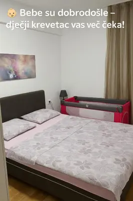 a bed in a room with a bed frame at Zoya Apartment in Podgorica