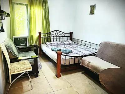 a bedroom with a bed and a couch and a chair at Apartment at villa with pool in Budva