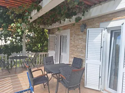 a patio with a table and chairs on a patio at Apartment at villa with pool in Budva