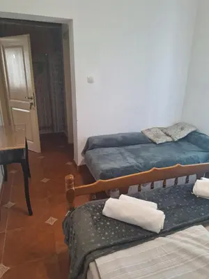 a room with two beds and a table and a table at Apartment at villa with pool in Budva
