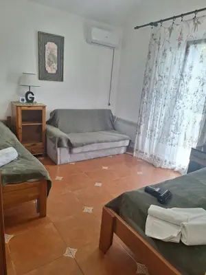 a living room with two beds and a couch at Apartment at villa with pool in Budva