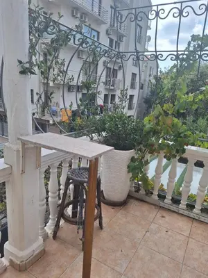 a table on a balcony with potted plants at Apartment at villa with pool in Budva