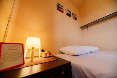 a bedroom with a bed and a table with a lamp at Explorer Podgorica in Podgorica