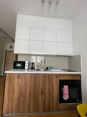 a kitchen with white cabinets and a sink and a microwave at Dream 1 apartment in Budva