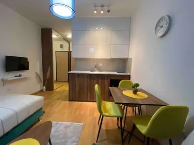 a kitchen and a living room with a table and chairs at Dream 1 apartment in Budva