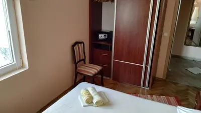a room with a bed and a chair and a cabinet at Apartments Abramovic in Sutomore