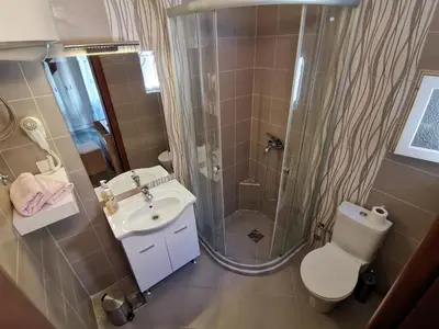 a bathroom with a shower and a toilet and a sink at Apartments Abramovic in Sutomore