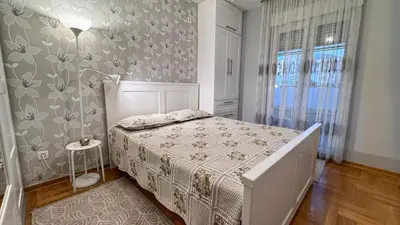 a bedroom with a bed and a wall with flowers at Incanto Adriatiko in Bar