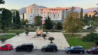 a parking lot with cars parked in front of a city at Incanto Adriatiko in Bar