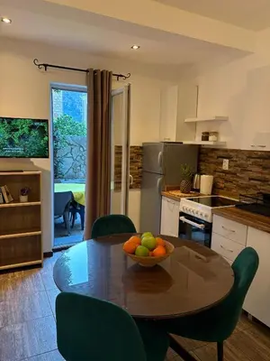 a kitchen with a table with a bowl of fruit on it at Apartments Bajkovic in Kotor