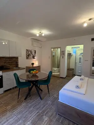 a living room with a table and a kitchen at Apartments Bajkovic in Kotor