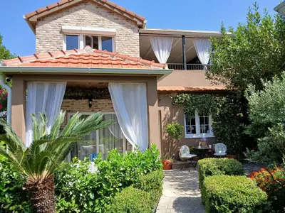 a house with a garden and a patio at Apartments Bajkovic in Kotor