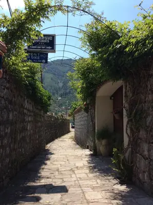 an alley with street signs in a stone building at Apartments Bajkovic in Kotor
