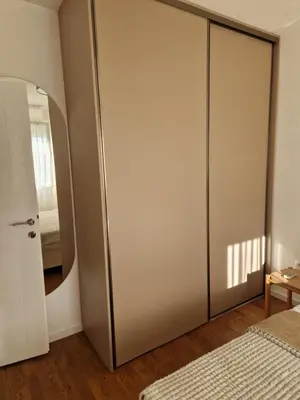 a bedroom with a sliding closet door with a mirror at Rosemary in Podgorica