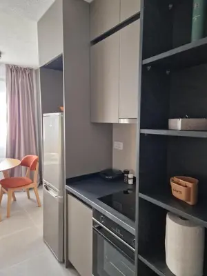 a kitchen with a refrigerator and a table with a chair at Rosemary in Podgorica