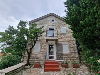 a brick house with a door and a balcony at Cliff House in Budva