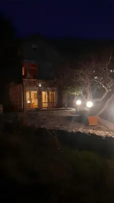 a car with headlights on in a driveway at night at Cliff House in Budva