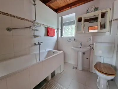 a bathroom with a tub and a toilet and a sink at Cliff House in Budva