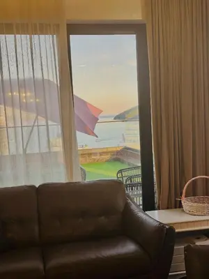 a living room with a couch and a large window at Penthouse Victoria in Budva