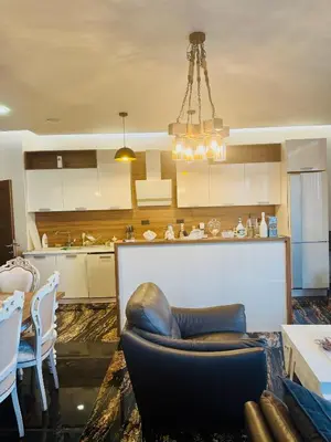 a living room with a couch and a kitchen at Penthouse Victoria in Budva