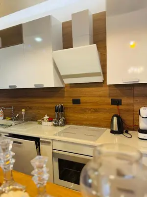 a kitchen with white cabinets and a stove top oven at Penthouse Victoria in Budva