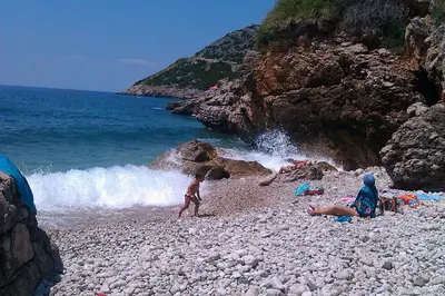 a group of people laying on a rocky beach at Holiday Home Siesta in Dobra Voda