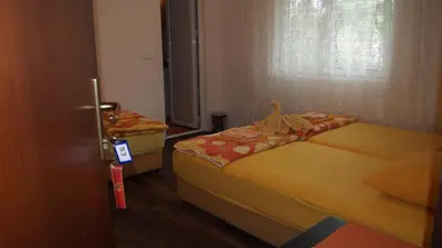 two beds in a small room with a window at Marko Apartment in Sutomore