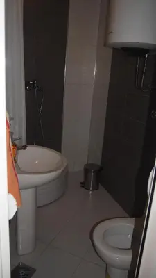 a bathroom with a white toilet and a sink at Marko Apartment in Sutomore