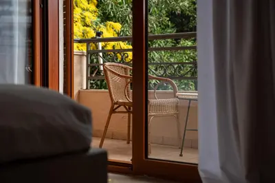 an open door with a chair and a table on a balcony at Maslina Residence in Budva